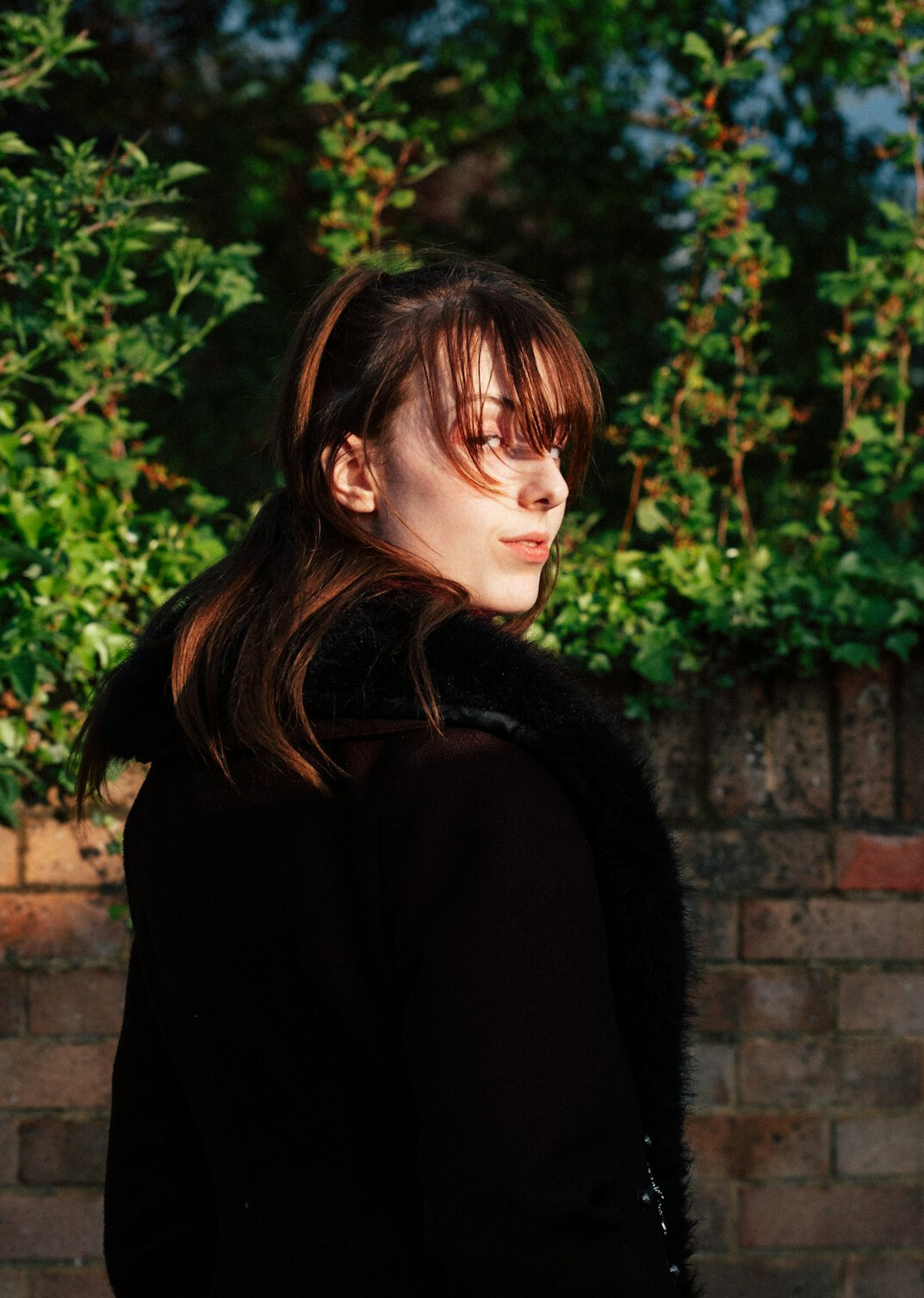 Studio portrait of a slovenian woman in her 20s with dark ponytail wearing a jacket