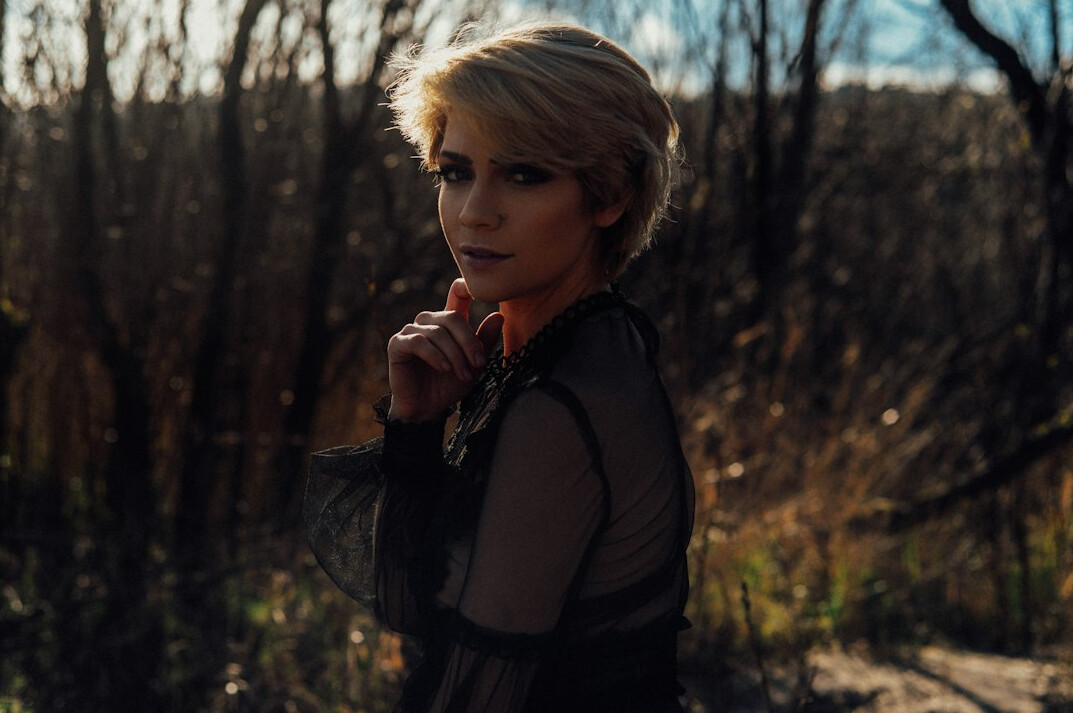 Studio portrait of a slovenian woman in her 40s with short blonde hair wearing a blouse